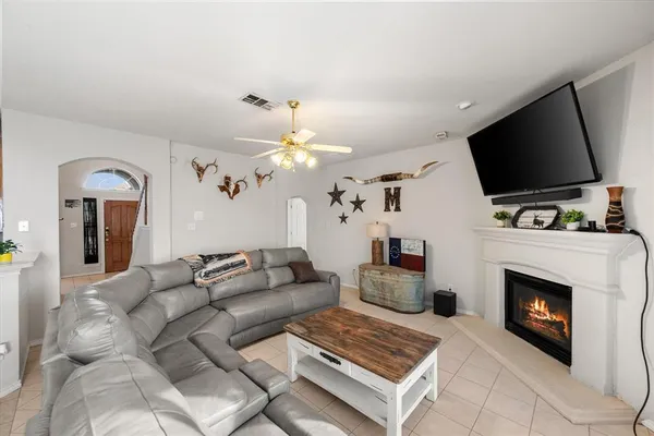 a living room with furniture a flat screen tv and a fireplace