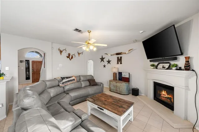 a living room with furniture a flat screen tv and a fireplace