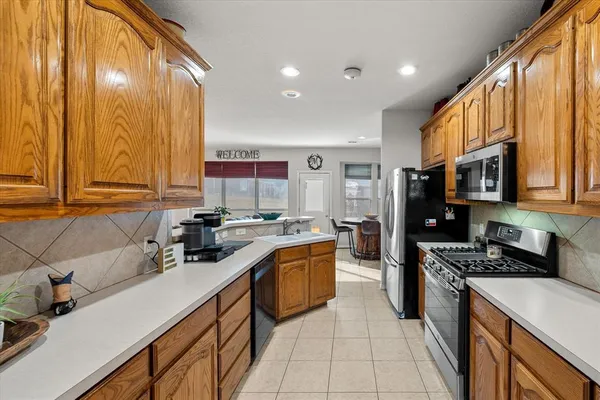 a kitchen with stainless steel appliances a sink dishwasher stove refrigerator and cabinets
