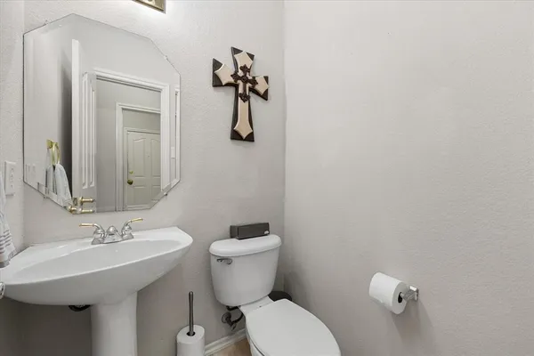 a bathroom with a sink a toilet and mirror