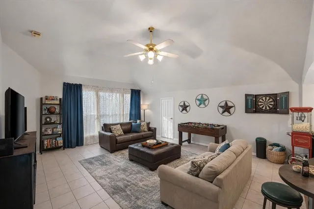 a living room with furniture a ceiling fan and a window