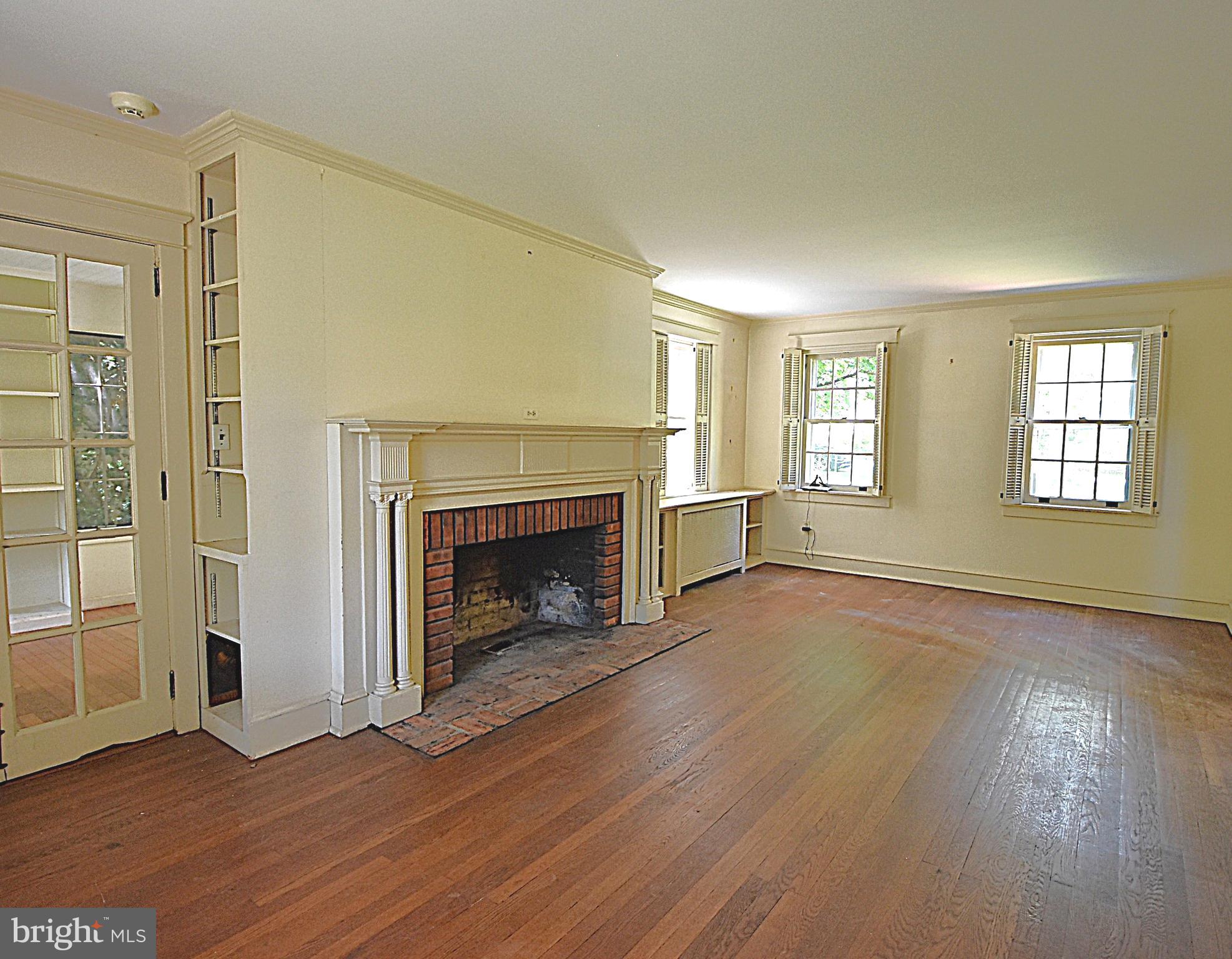 19 Farm Road Wayne, PA 19087 - Photo 8 of 41 an empty room with wooden floor fireplace and windows