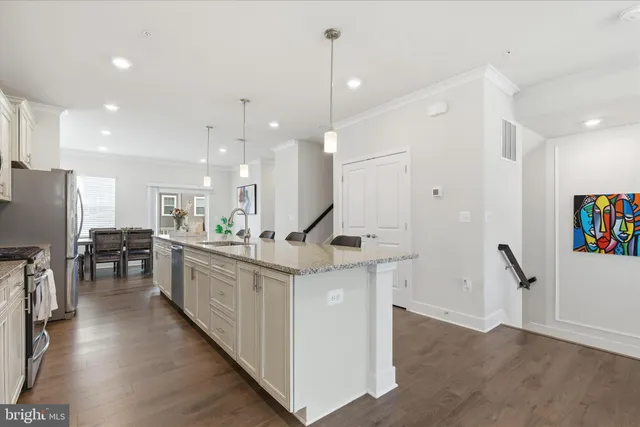 a open kitchen with stainless steel appliances granite countertop a stove and a wooden floors