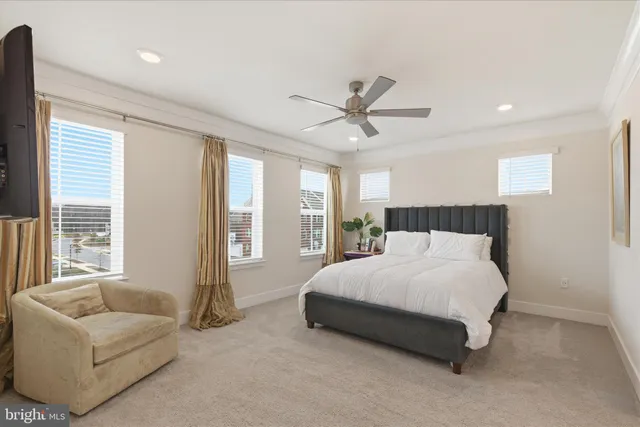 a spacious bedroom with a bed a couch and a large window