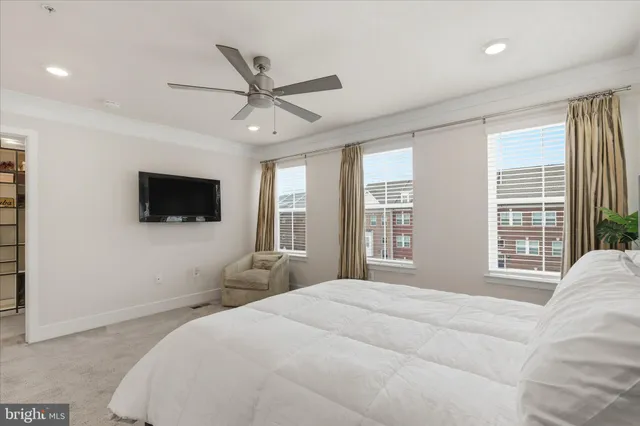 a spacious bedroom with a bed and a flat screen tv