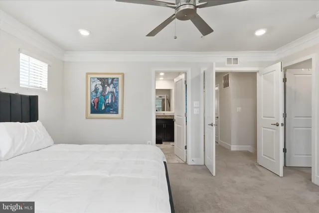 a bedroom with a large bed and ceiling fan