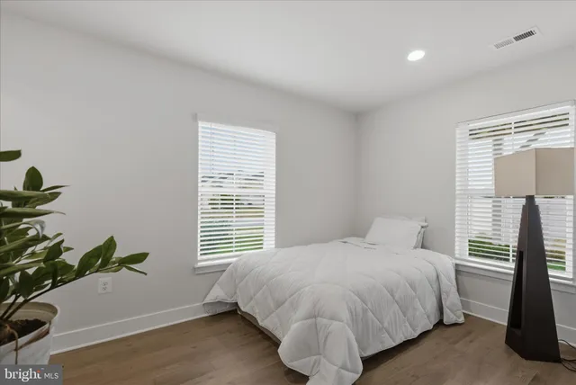 a bedroom with a bed and a potted plant