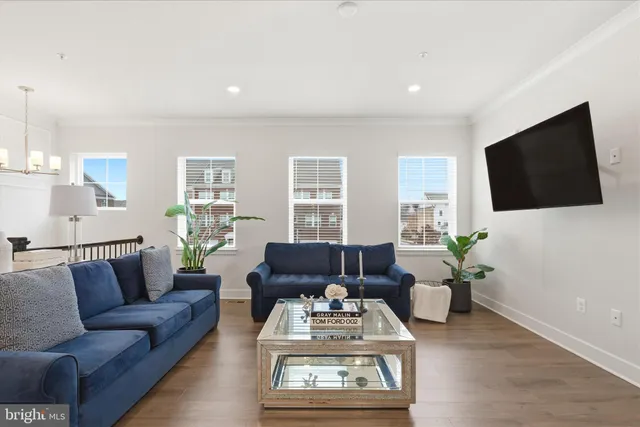 a living room with furniture a flat screen tv and a large window