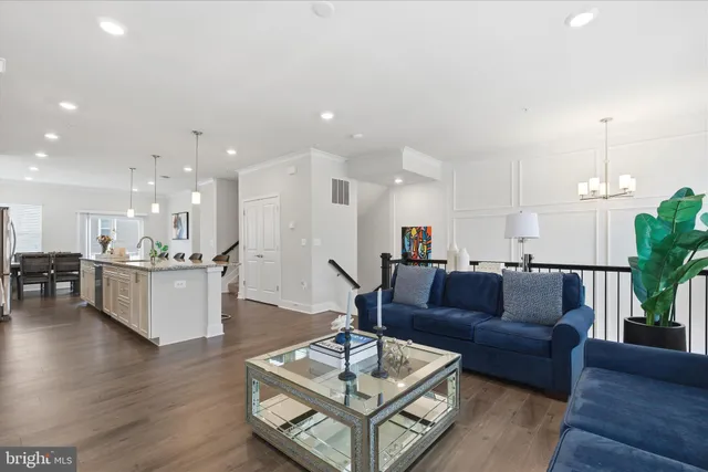 a living room with furniture and a dining table with wooden floor