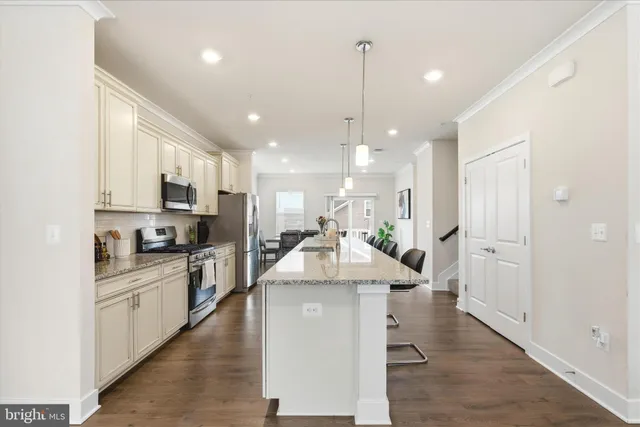 a kitchen with stainless steel appliances kitchen island granite countertop a stove and a sink