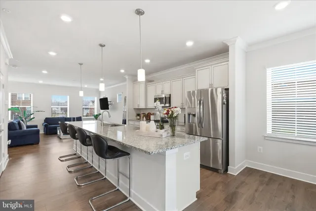 a kitchen with counter top space a sink appliances and living room view