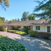 a view of a house with a yard and potted plants