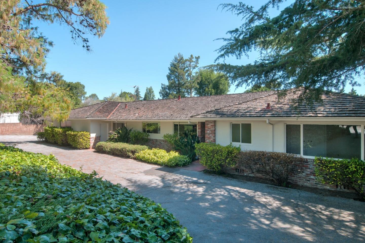 a view of a house with a yard and potted plants