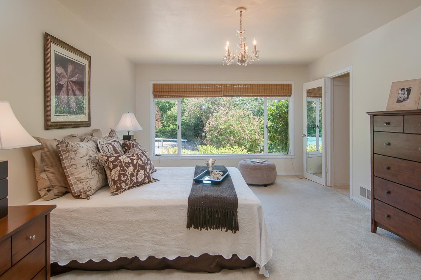 480 Darrell Road Hillsborough, CA 94010 - Photo 12 of 24 a bedroom with a bed and a chandelier