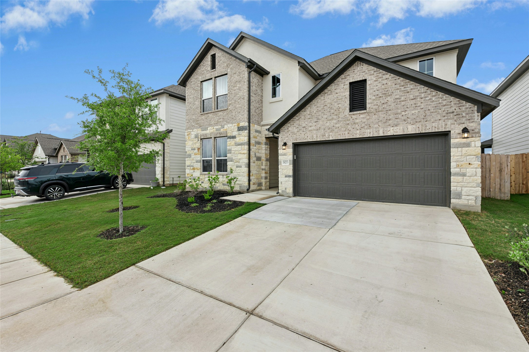 16213 Smithers Road Manor, TX 78653 - Photo 2 of 37 View of front facade with concrete driveway, an attached garage