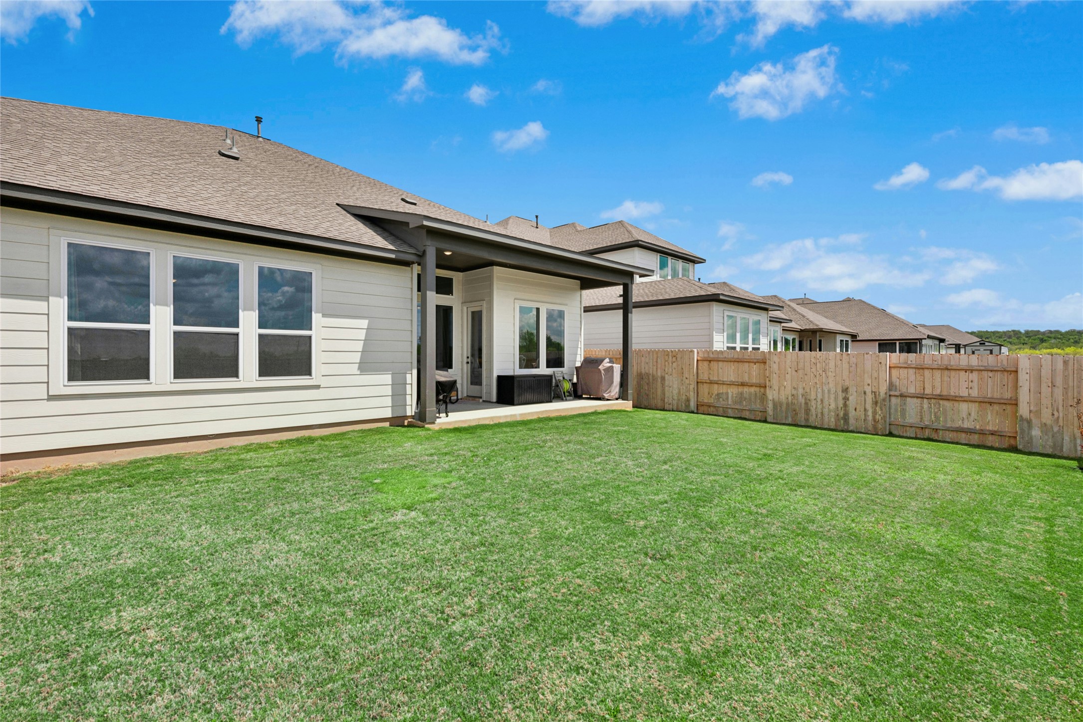 16213 Smithers Road Manor, TX 78653 - Photo 36 of 37 Back of property with a patio area, a fenced backyard and room for pool.