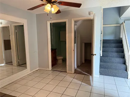 an empty room with closet and chandelier fan