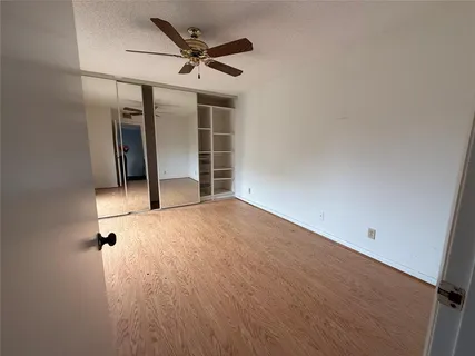 an empty room with a ceiling fan and window