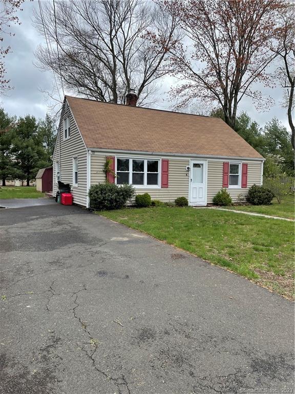 a view of house with a yard and potted plants