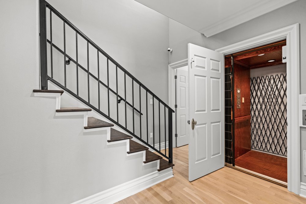 1609 Hartford Road, Unit A Austin, TX 78703 - Photo 39 of 39 Hardwood flooring leads to a convenient interior elevator alongside a modern staircase.
