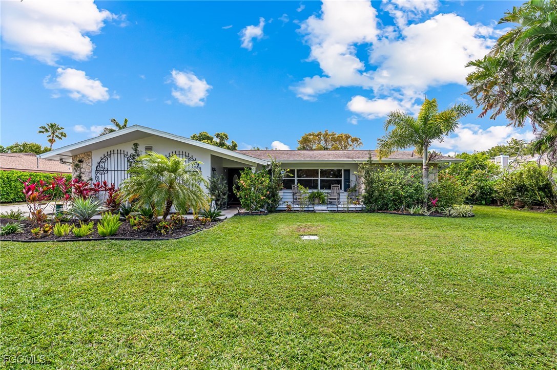 a view of a house with a big yard and potted plants