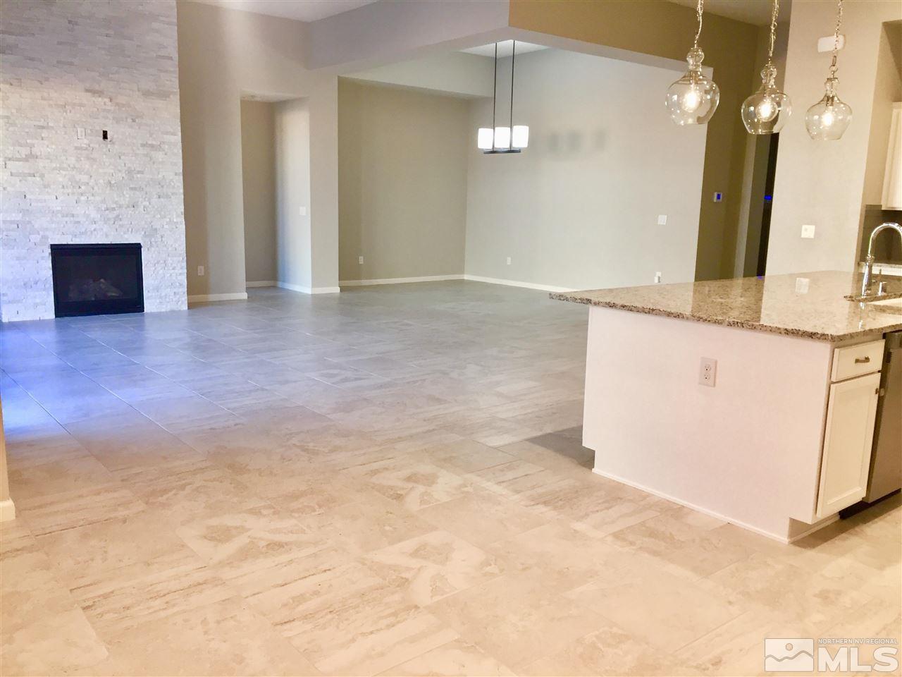 9485 Hawkshead Road Reno, NV 89521 - Photo 8 of 31 an empty room with kitchen view and mirror