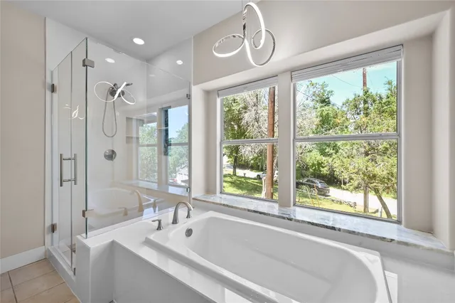 a bathroom with a large tub a sink and a large window