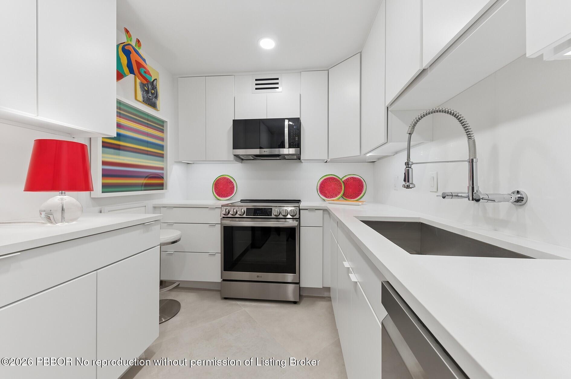 3800 Washington Road, Unit 909 West Palm Beach, FL 33405 - Photo 4 of 9 a kitchen with a sink cabinets and appliances