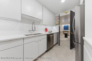 3800 Washington Road, Unit 909 West Palm Beach, FL 33405 - Photo 5 of 9 a kitchen with stainless steel appliances granite countertop a sink refrigerator and cabinets