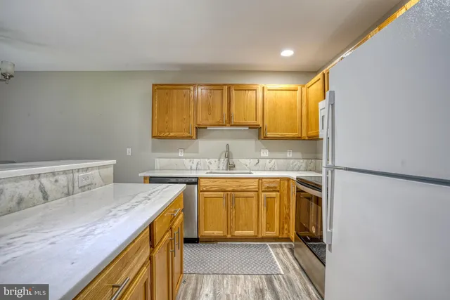 a kitchen with stainless steel appliances granite countertop a refrigerator sink and stove