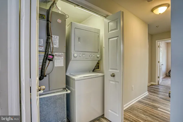 a view of a hallway with wooden floor and closet