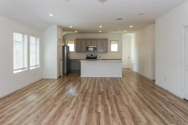 a view of a kitchen with cabinets stainless steel appliances a sink and a window