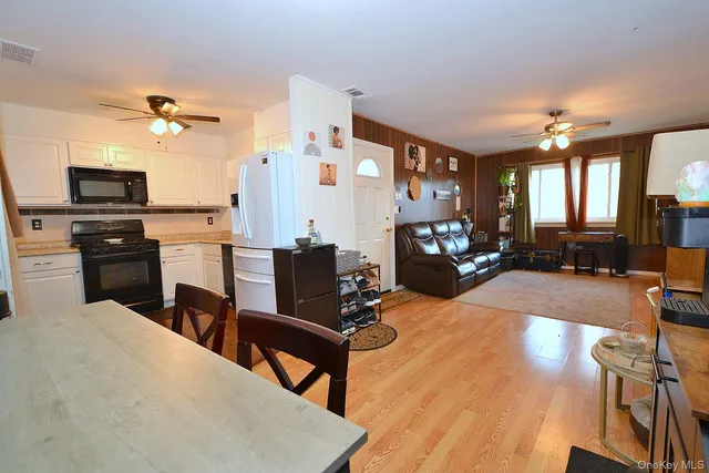 a living room with furniture a flat screen tv and kitchen view