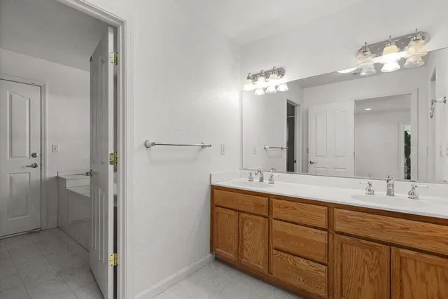 a bathroom with a double vanity sink and a mirror