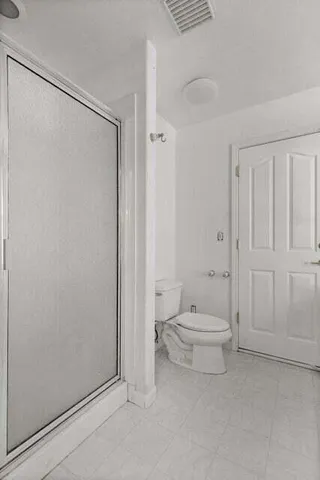 a bathroom with a toilet a sink and shower
