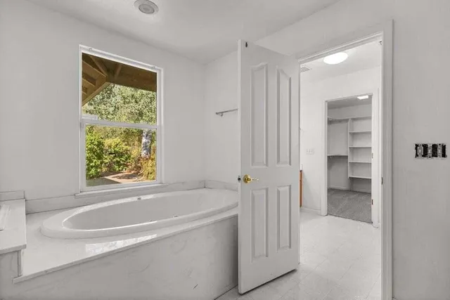 a white bath tub sitting next to a shower