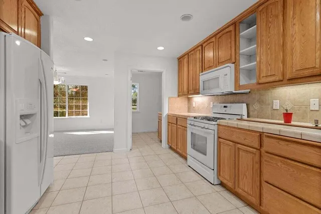 a kitchen with stainless steel appliances granite countertop a refrigerator and a stove top oven