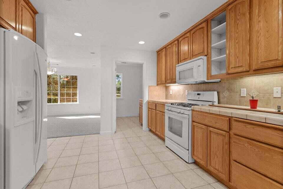 16840 Hawthorne Avenue Anderson, CA 96007 - Photo 6 of 37 a kitchen with stainless steel appliances granite countertop a refrigerator and a stove top oven