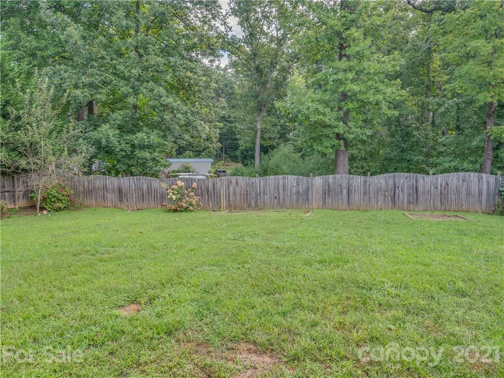 65 Wildbriar Road, Unit 49 Fletcher, NC 28732 - Photo 40 of 43 a view of a backyard with large trees and wooden fence