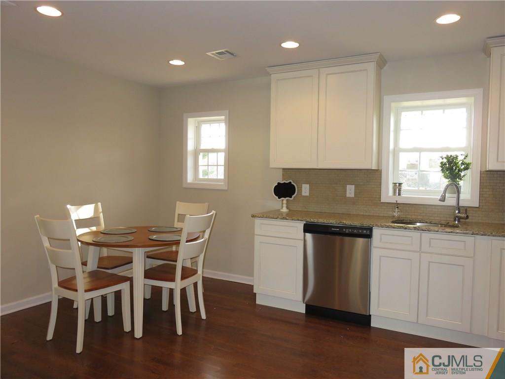 7 Roger Road Edison, NJ 08817 - Photo 5 of 14 a kitchen with stainless steel appliances granite countertop a stove a sink a microwave a dining table and chairs