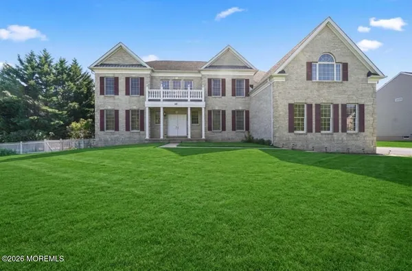 a front view of a house with a yard and trees