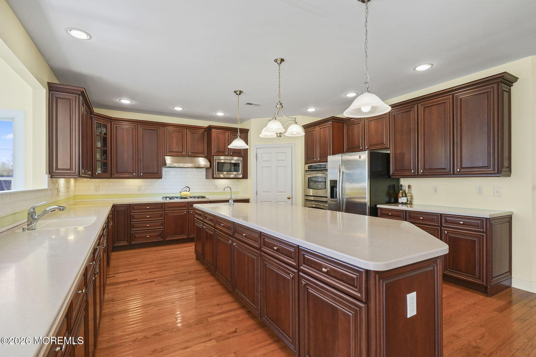 10 Rockingham Court Manalapan, NJ 07726 - Photo 17 of 91 a large kitchen with cabinets a sink and a stove
