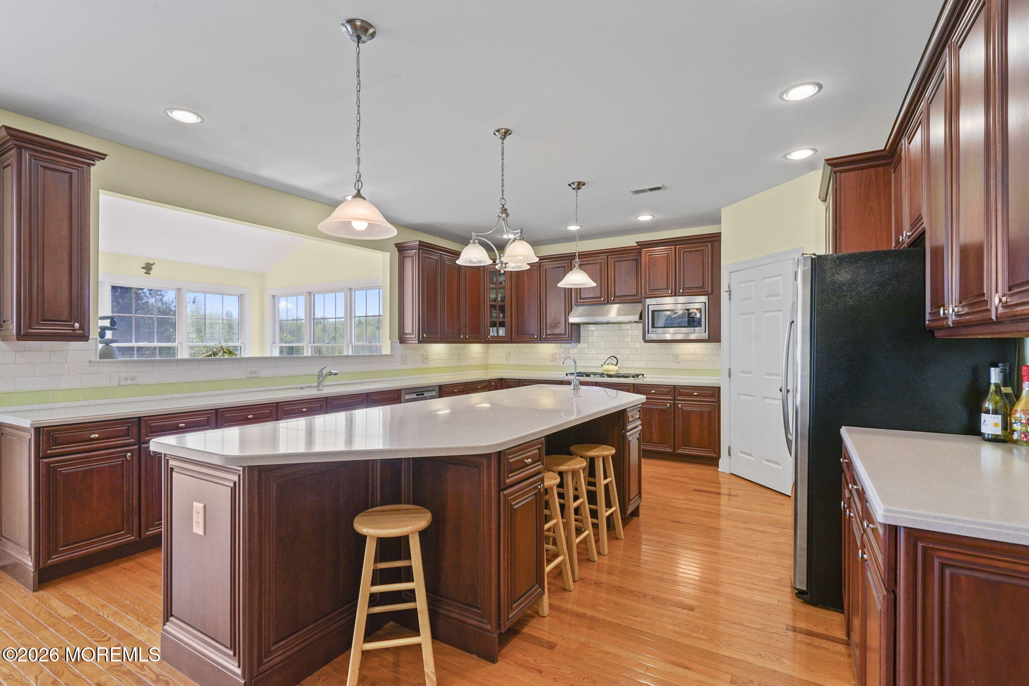 10 Rockingham Court Manalapan, NJ 07726 - Photo 22 of 91 a kitchen with kitchen island a counter top space a sink stainless steel appliances and cabinets