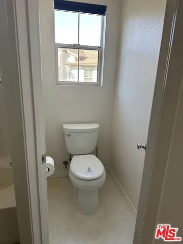 a white toilet sitting next to a bathroom sink and a vanity