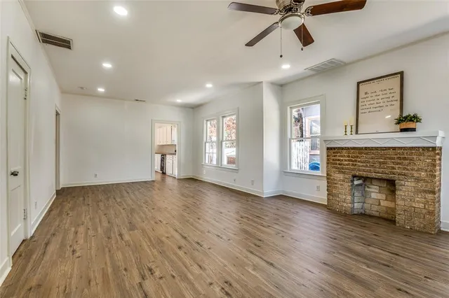 a view of empty room with wooden floor and fireplace