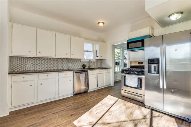 a kitchen with granite countertop white cabinets and stainless steel appliances