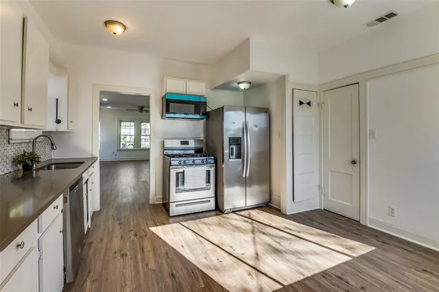 a kitchen with stainless steel appliances granite countertop a refrigerator and a sink