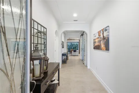 a view of a hallway with a dining table and a chandelier