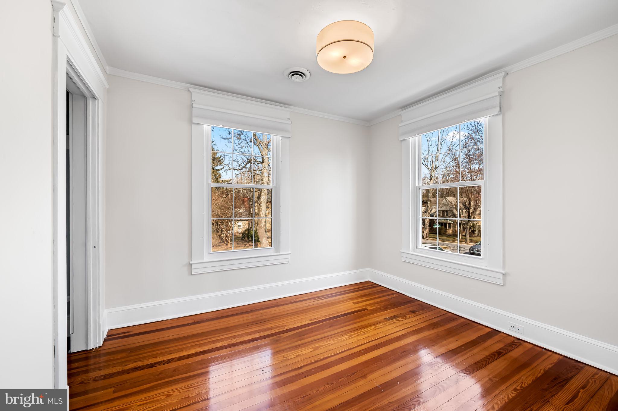 703 Chumleigh Road Baltimore, MD 21212 - Photo 23 of 41 an empty room with wooden floor and windows