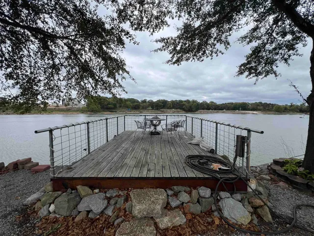a view of a lake with a bench and trees around